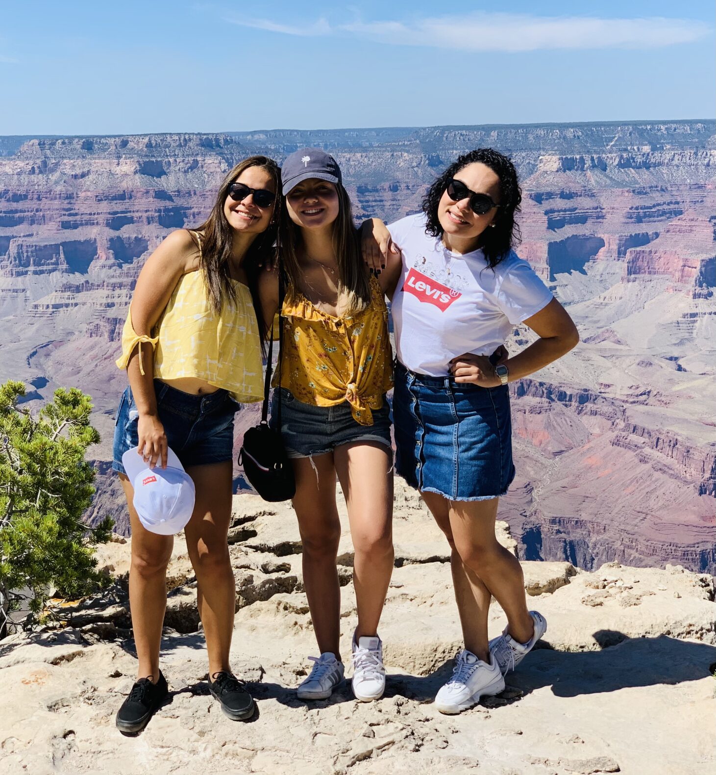 Camp Connect USA - Three women in outdoor gear posing next to the Grand Canyon.